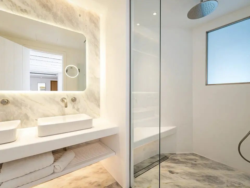 Exclusive Suite with Outdoor Hot Tub: Luxury bathroom with double sinks, large mirror, and glass shower enclosure