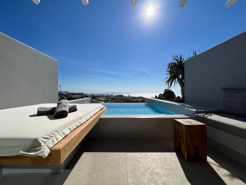 Junior Suite with Private Heated Pool: Modern patio with lounge beds beside a small infinity pool overlooking the sea