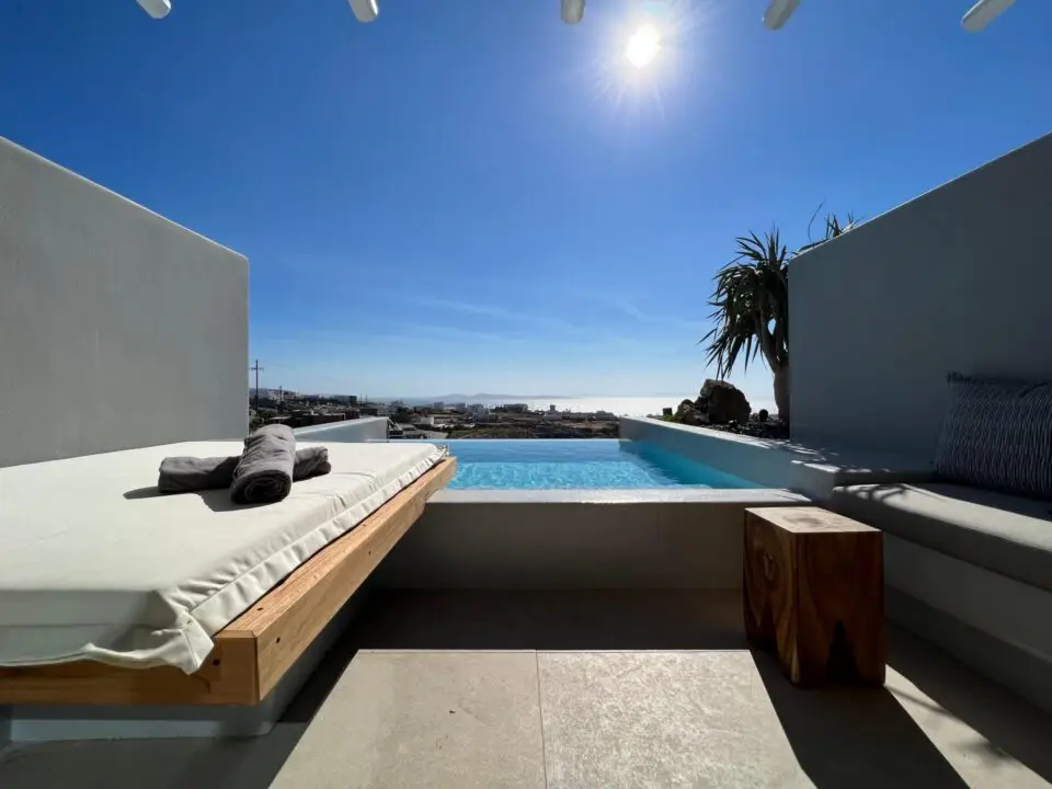 Junior Suite with Private Heated Pool: Modern patio with lounge beds beside a small infinity pool overlooking the sea