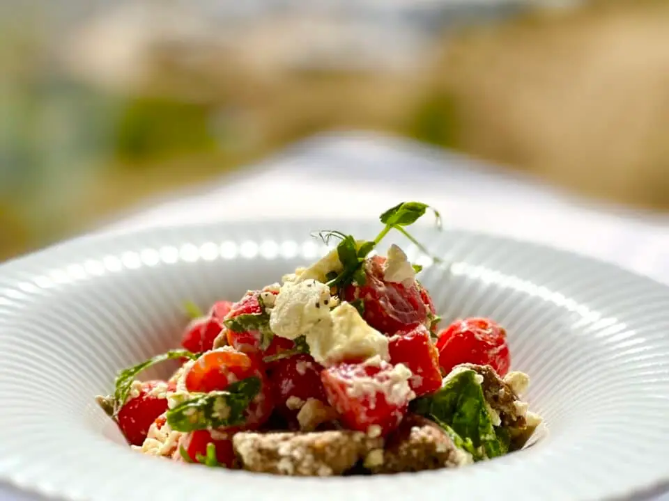 Nomia Mykonos Sunset Suites Menu: Tomato and Mykonian cheese green salad in a white bowl