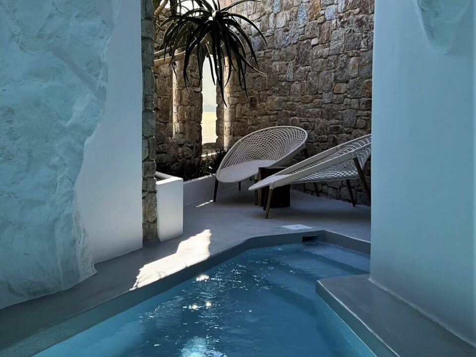 The Cave Pool Experience Suite: Private pool opening onto a stone courtyard with lounge chairs and potted plants