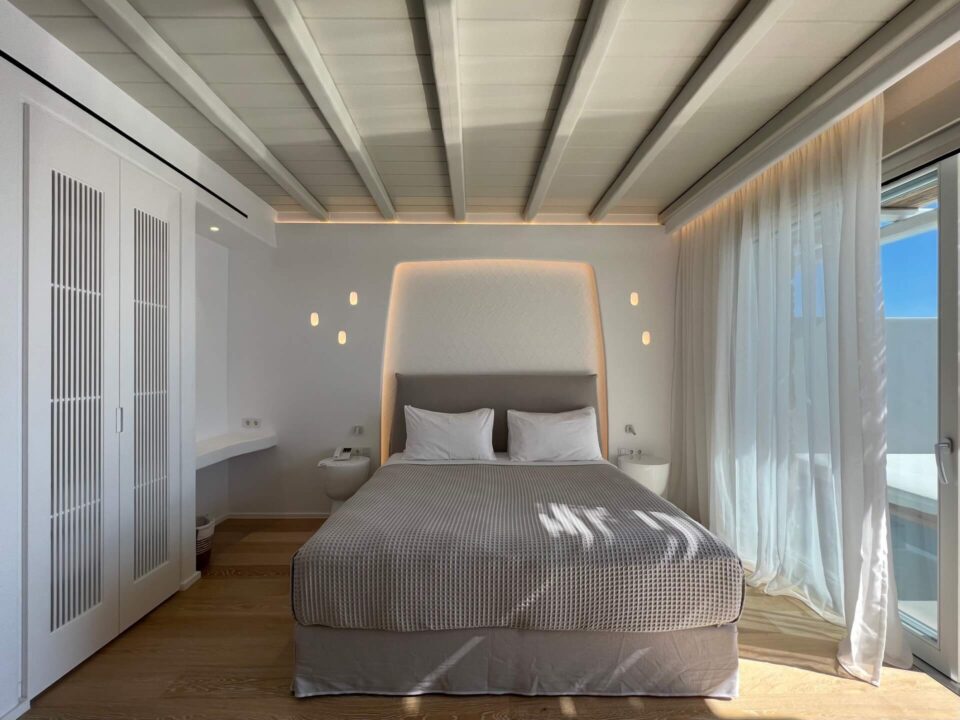 Junior Suite with Private Heated Swimming Pool: Modern suite with a king-sized bed, built-in wardrobe, and sheer curtains by a window