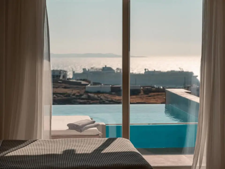 Premium Suite with Private Heated Swimming Pool: Luxury suite with a view of an infinity private pool and the sea through open curtains