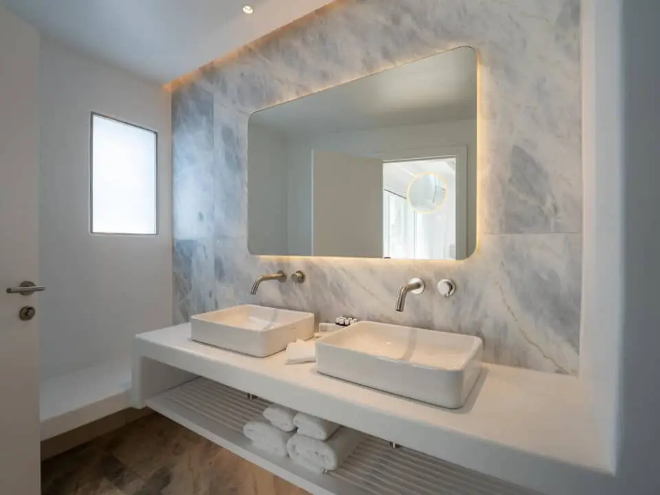 Premium Suite with Private Heated Swimming Pool: Modern bathroom vanity with double sinks and a backlit mirror