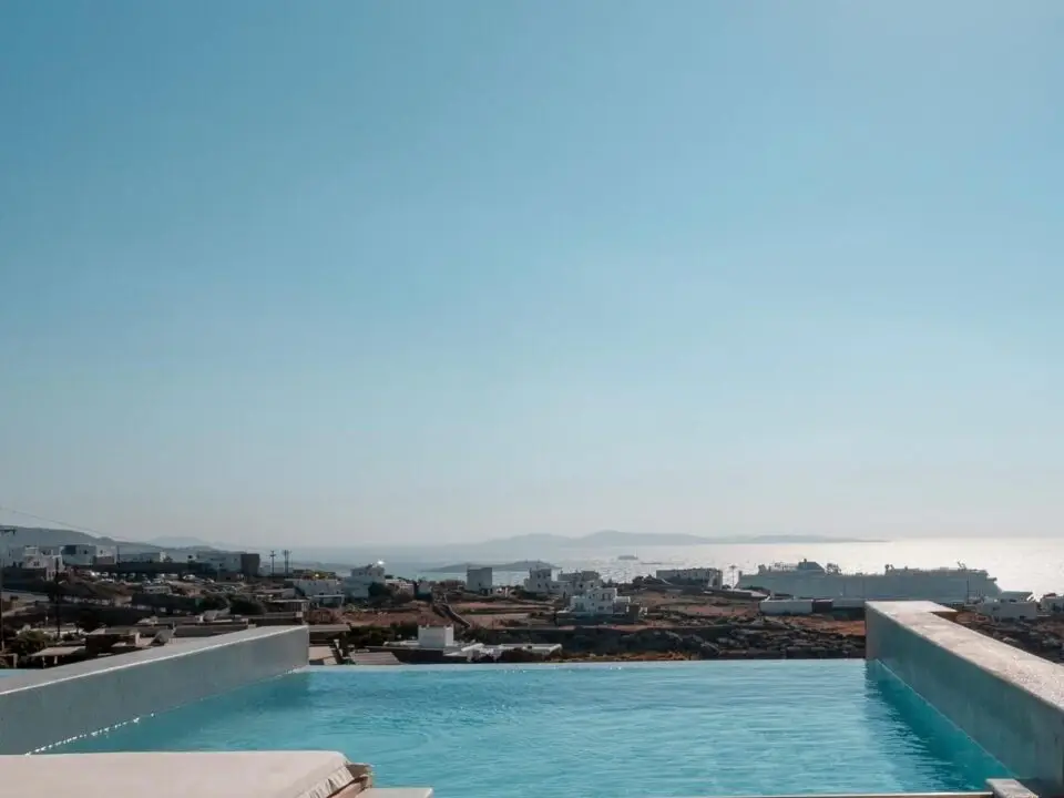 Premium Suite with Private Heated Swimming Pool: Infinity pool overlooking the sea and a coastal town from suite's terrace