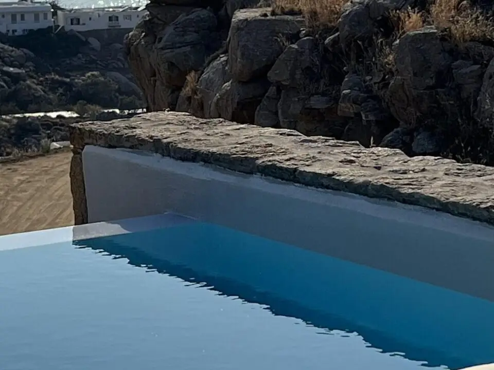 Premium Suite with Private Heated Swimming Pool overlooking a rocky seaside cliff and sparkling ocean