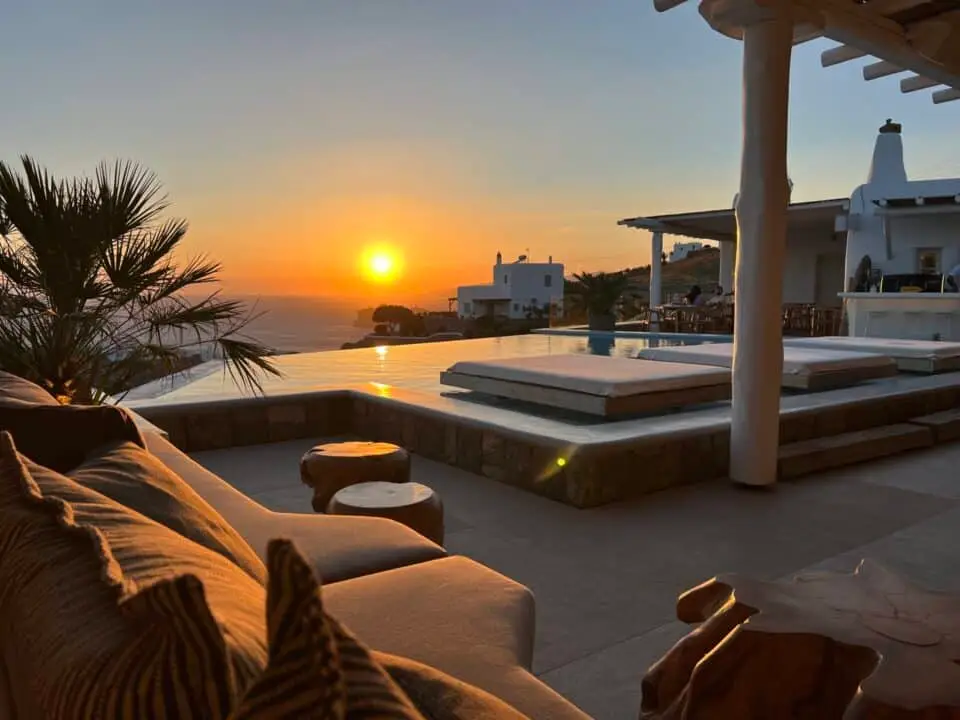 Nomia Mykonos Sunset Suites Lounge Area: Sunset over the infinity pool, with white villas and lounge seating