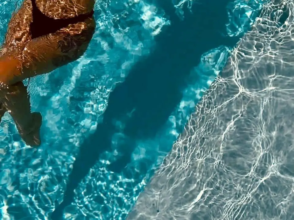 Nomia Mykonos Sunset Suites Pool: Woman floating in a swimming pool in a black bikini