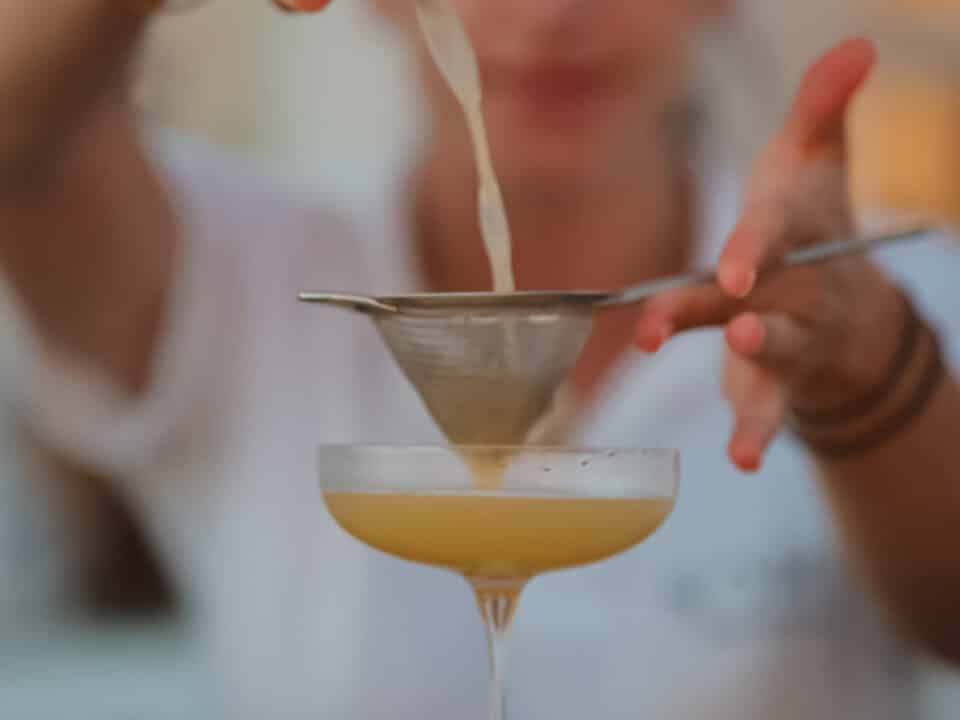 Nomia Mykonos Sunset Suites Bar: Bartender straining a cocktail into a coupe glass