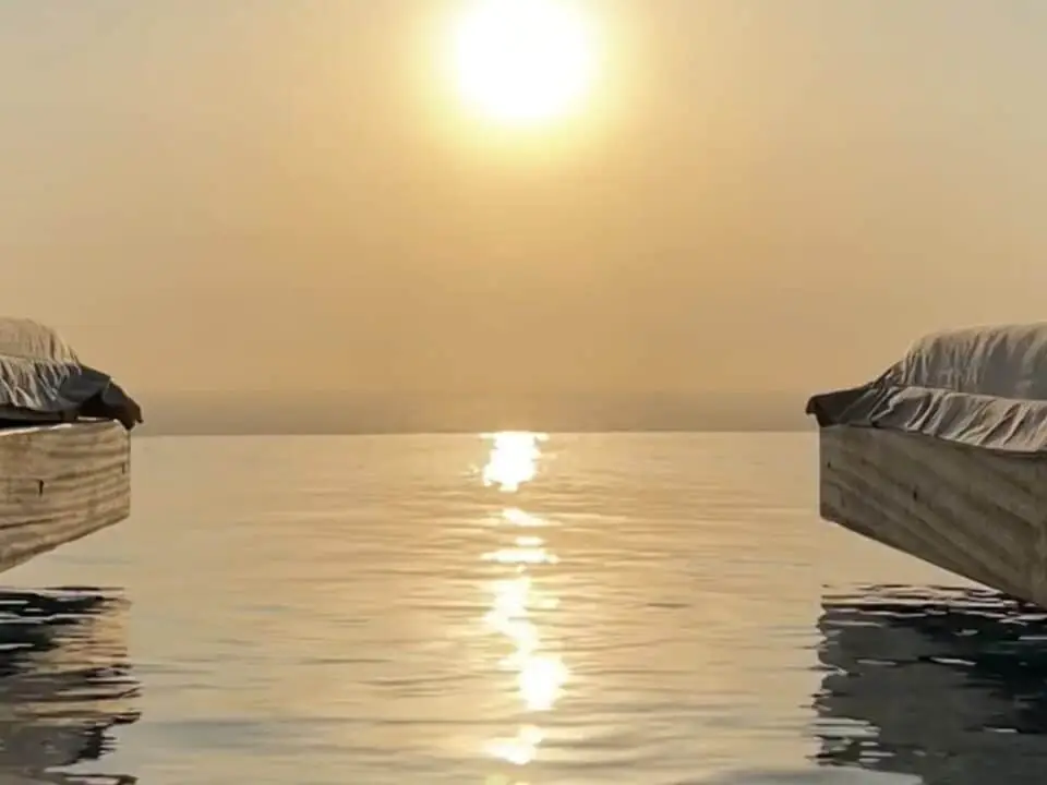 Nomia Mykonos Sunset Suites: Sunset over Infinity Pool between two covered poolside loungers